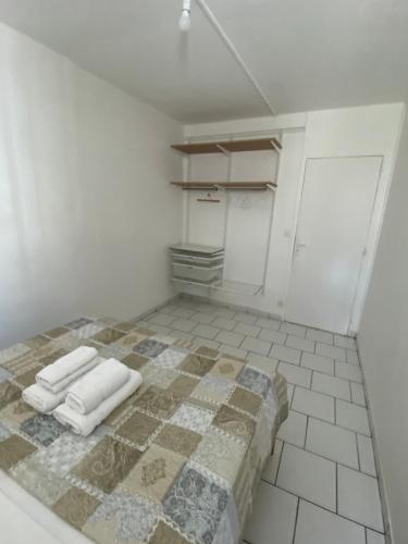 萨莱比梅Appartement moderne, 2 chambres, proche aéroport • CHU • port的客房铺有瓷砖地板,配有1张床和毛巾。