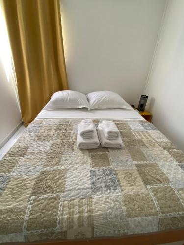 萨莱比梅Appartement moderne, 2 chambres, proche aéroport • CHU • port的一间卧室配有一张床,上面有两条毛巾