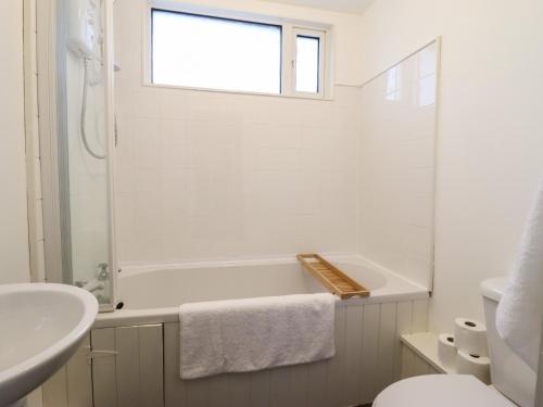 布莱奈费斯蒂尼奥格1 Llwyn Hir的白色的浴室设有浴缸和水槽。