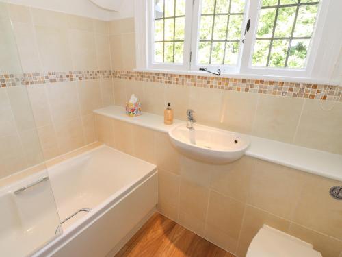 鲍内斯温德米尔Brunton Lodge的浴室配有盥洗盆、卫生间和浴缸。