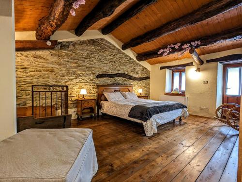 PaesanaCasa Nenella的一间卧室设有两张床和石墙