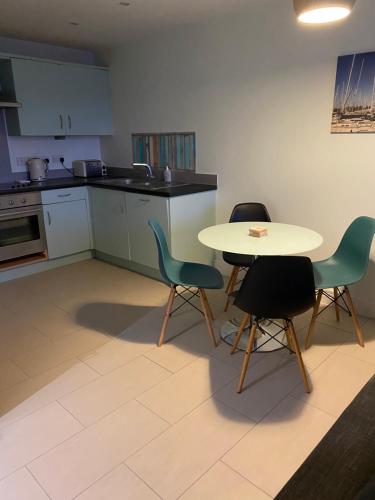 戈斯波特Stunning Marina apartment Gosport Portsmouth的厨房配有桌子、两把椅子和一张桌子
