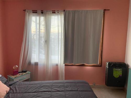 乌斯怀亚Hui-na的一间卧室配有一张床和一个带镜子的窗户