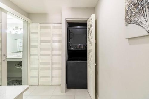 金斯敦City Edge La Vie的厨房配有黑色冰箱,其中配有电视