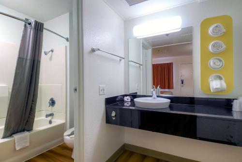 棕榈泉棕榈泉市区速6汽车旅馆的一间带水槽和镜子的浴室