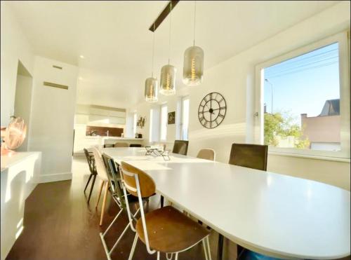 科尔马Charmante maison - centre-ville Colmar的一间用餐室,配有一张白色的大桌子和椅子