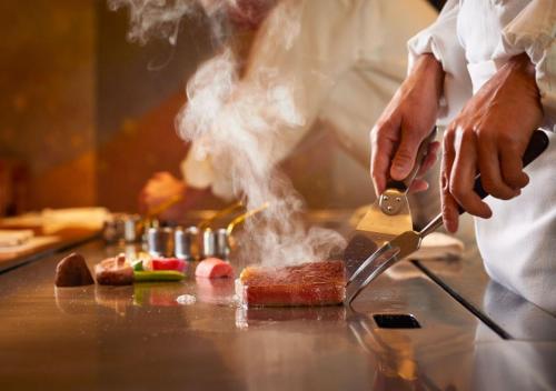 东京东京帝国酒店的厨师用刀在柜台上烹饪食物