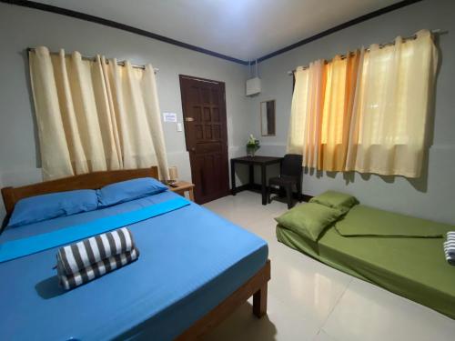 邦劳Alona Bohol Backpackers Hostel的一间卧室配有两张床和一张书桌