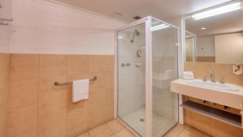旺加拉塔City Reach Motel的带淋浴和盥洗盆的浴室