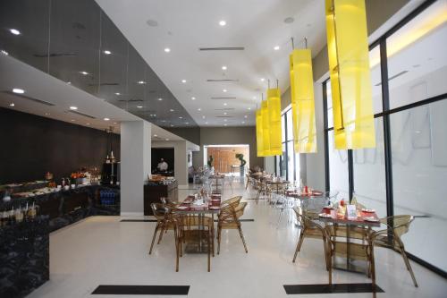 班加罗尔Keys Select by Lemon Tree Hotels, Whitefield, Bengaluru的一间带桌椅的餐厅和一间酒吧