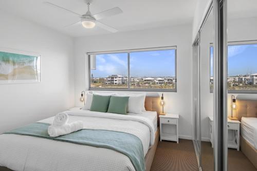 卡瓦纳华特斯Pool, 100m to Hosp, 3 TVs, 3 Beds - Lakefront Aquarius Apartment的白色的卧室设有一张大床和一个窗户