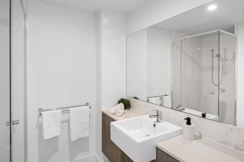 卡瓦纳华特斯Pool, 100m to Hosp, 3 TVs, 3 Beds - Lakefront Aquarius Apartment的白色的浴室设有水槽和镜子