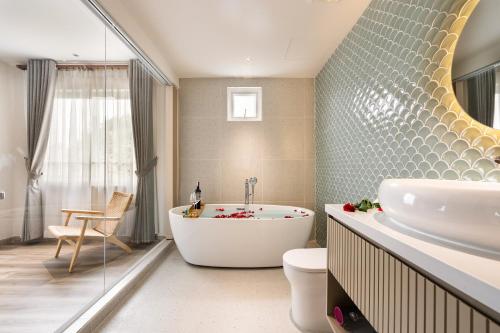 胡志明市Jovia Hotel的带浴缸、卫生间和盥洗盆的浴室