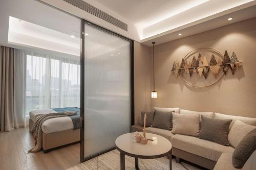 重庆重庆壹棠酒店公寓的客厅配有沙发和1张床