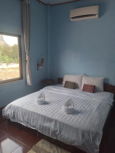 NongkhiawLamorn Guesthouse的蓝色卧室配有一张大床和两张毛巾