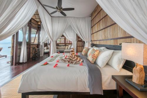 Pulau BiriePapua Paradise Eco Resort的一间卧室配有一张带吊扇的床