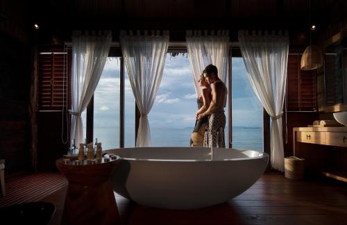 Pulau BiriePapua Paradise Eco Resort的男人和女人站在浴室的浴缸里