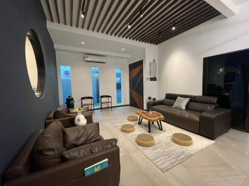 怡保5000 SQFT BRAND NEW Semi-D Hype Home 10pax的客厅配有沙发和桌子