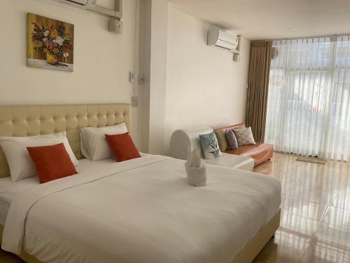 尖竹汶Na cha lae 2的卧室配有一张白色的大床和一张沙发。
