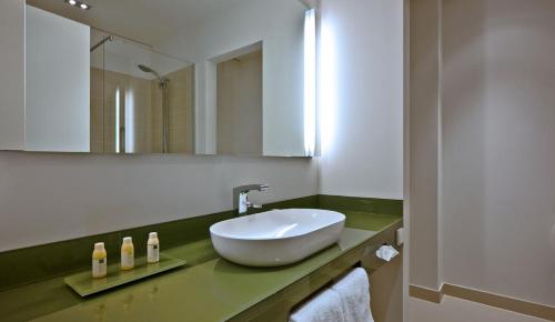 柏林柏灵城中区COSMO酒店的浴室设有白色水槽和镜子