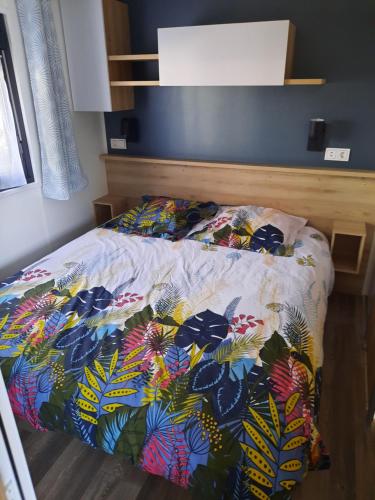 波讷地区圣朱利安jpp marie ange proprietaire的一间卧室配有一张带五颜六色棉被的床