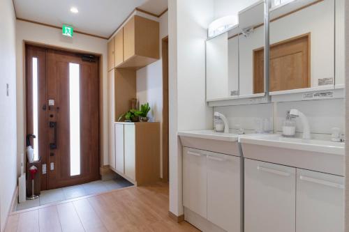 恩纳Y's沖縄リゾートベースNo.1的厨房配有白色橱柜和水槽
