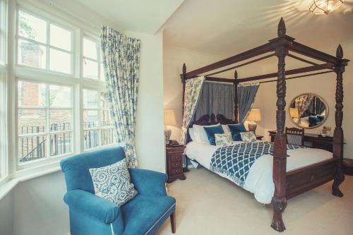 沃辛芬顿庄园酒店的一间卧室配有天蓬床和蓝椅