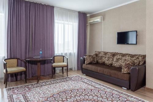 阿斯塔纳阿扎迈特酒店的客厅配有沙发和桌子