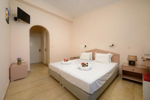 贝尼蔡斯Siora Leni Hotel的一间卧室配有一张白色大床,床上有鲜花