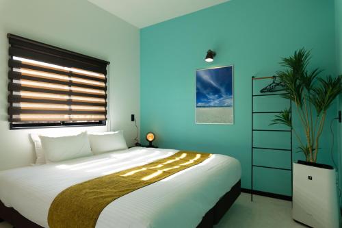 宫古岛クリスタルパーク久松的一间卧室设有一张大床和蓝色的墙壁