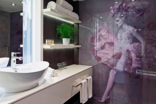 维也纳维也纳万丽酒店 - 万豪生活酒店的一间带水槽和淋浴的女人的浴室