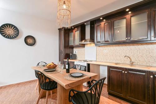 斯泰里达Delight Apartments suites的厨房配有木桌和黑色橱柜。