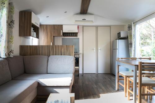 罗列特海岸Camping Tucan - Mobile Homes by Lifestyle Holidays的客厅以及带沙发和桌子的厨房。