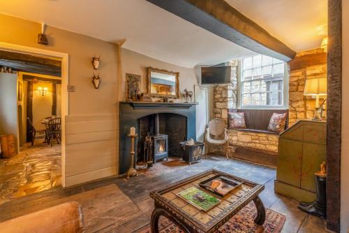温什科姆Stunning 2 Bed Cotswold Cottage Winchcombe的客厅设有壁炉和桌子