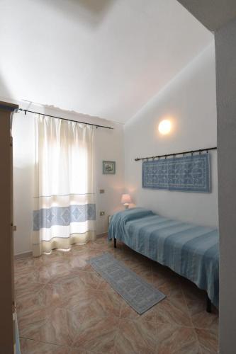 马达莱纳Villetta a schiera的一间卧室设有一张床和一个窗口