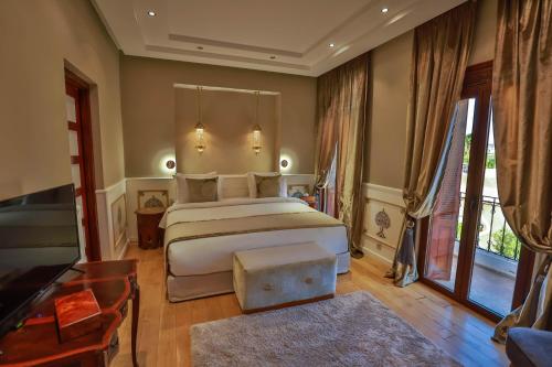 非斯Riad Mayfez Suites & Spa的一间卧室设有一张大床和一个大窗户
