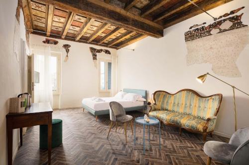 曼托瓦Residenza Giulio Romano的一间卧室配有一张床和一张沙发