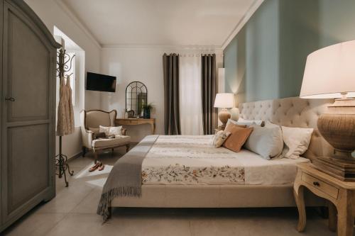 巴勒莫Palazzo Natoli Boutique Hotel的一间卧室配有一张大床和一把椅子