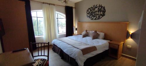 马达巴Moab Land Hotel的一间卧室设有一张大床和一个窗户。