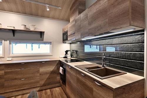 列维Economy Autto的厨房配有木制橱柜、水槽和窗户。