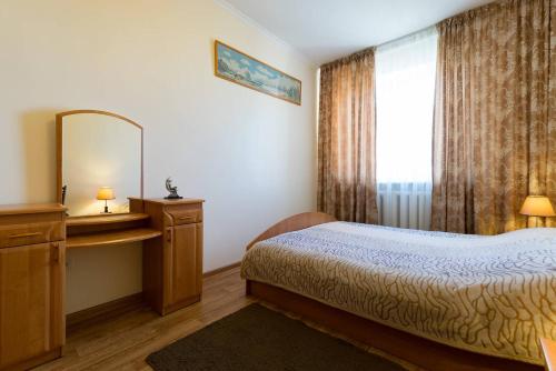 阿拉木图西莫尔娜杰日达公寓的一间卧室配有一张床、镜子和窗户