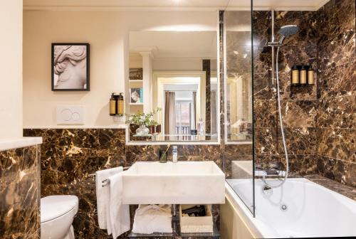 罗马涅尔瓦精品酒店 的一间带水槽、浴缸和卫生间的浴室