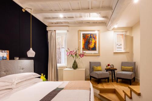 罗马涅尔瓦精品酒店 的一间卧室配有一张床和两把椅子