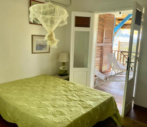 Grande AnseChambre chez l'habitant à L' Amirade chez Michelle的一间带绿色床的卧室和一个阳台