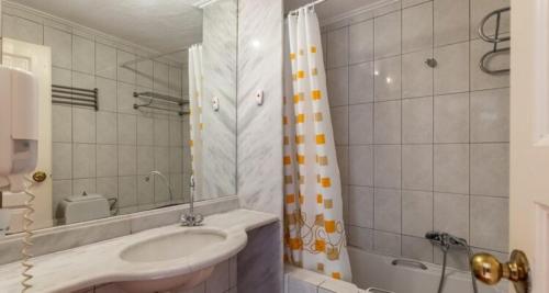 斯科派洛斯Rigas Hotel Skopelos的一间带水槽和淋浴的浴室