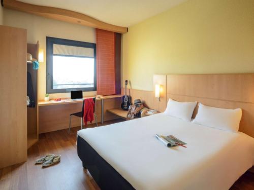 卡尔达诺阿尔坎波米兰马尔彭萨宜必思酒店的酒店客房设有一张白色大床和一张书桌