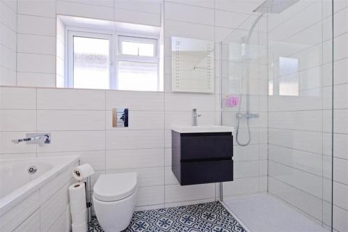 KentStunning family home, walking distance to Herne Bay Beach!的白色的浴室设有卫生间和水槽。