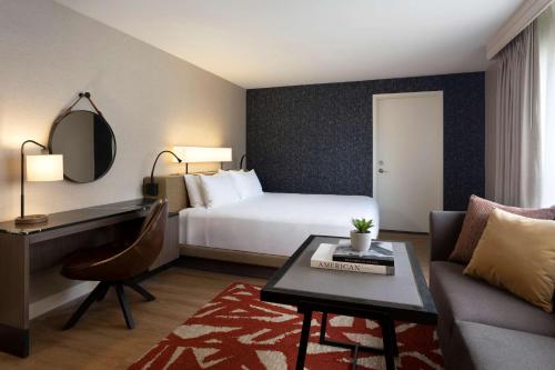 圣安东尼奥圣安东尼奥河畔步道凯悦酒店的酒店客房配有床、沙发和桌子。