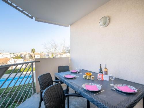 勒格罗-迪鲁瓦Apartment Les Caraïbes-1 by Interhome的阳台上配有带葡萄酒瓶和玻璃杯的桌子
