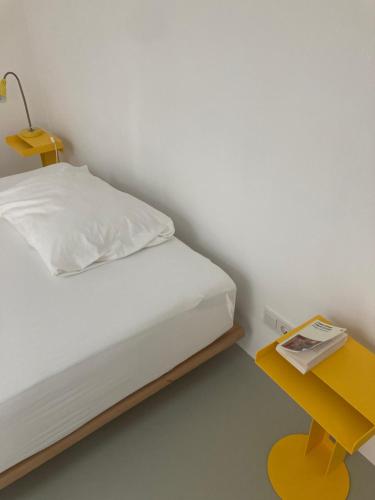 蒂罗尔州霍尔Bretzenstudios的一间卧室配有一张床和一张黄色的桌子